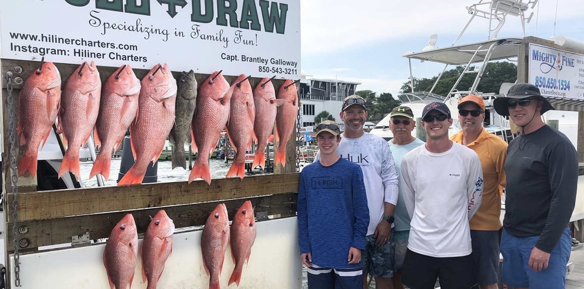 Team of anglers showing their catch on shore.