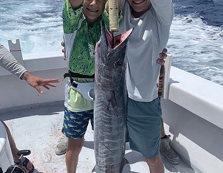 Two boys holding up a fish.