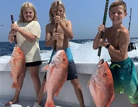  Three kids holding up red snapper.