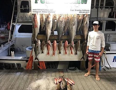  Teen poses next to HiLiner sign with fish caught.