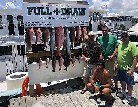  Team of men pose on the dock with the fish caught.